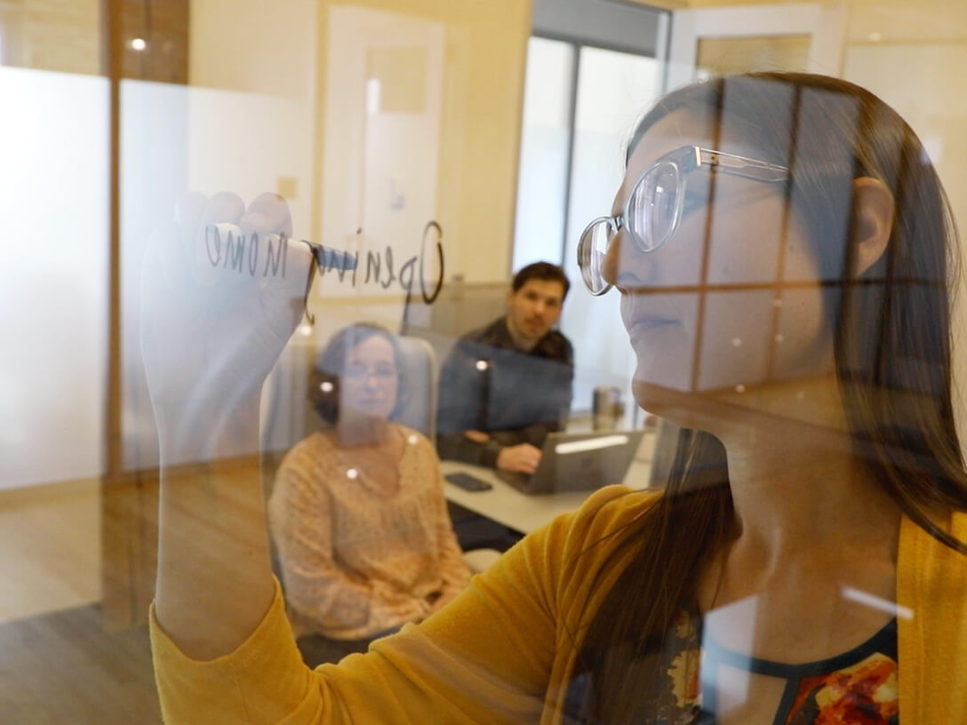 Woman writing on glass dry erase board